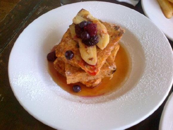 Delicious stack of Gluten Free French Toast, with banana, berries and maple syrup. MMMM!