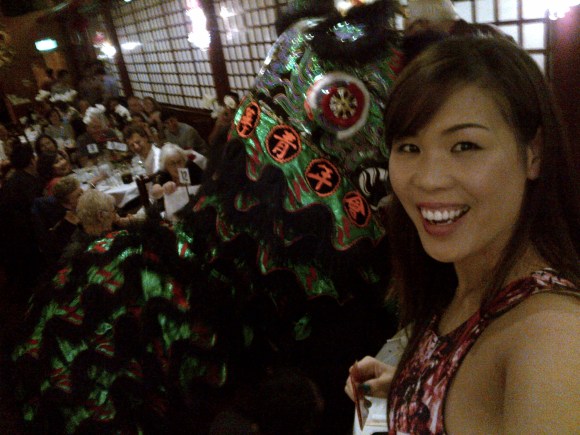 I'm standing on a chair holding my red packet in the air so that the lion has to climb to get it!